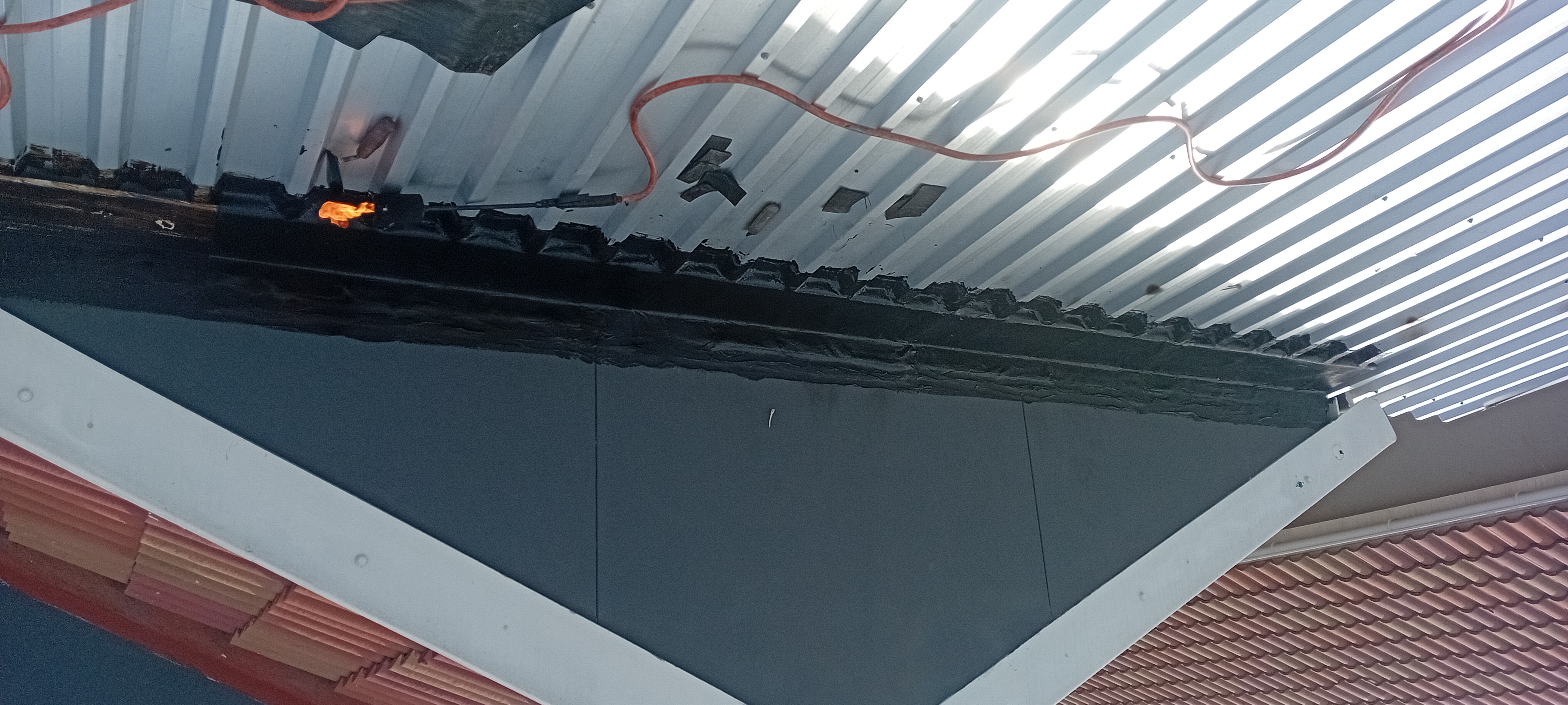 Close-up of torch-on waterproofing against the roof edge