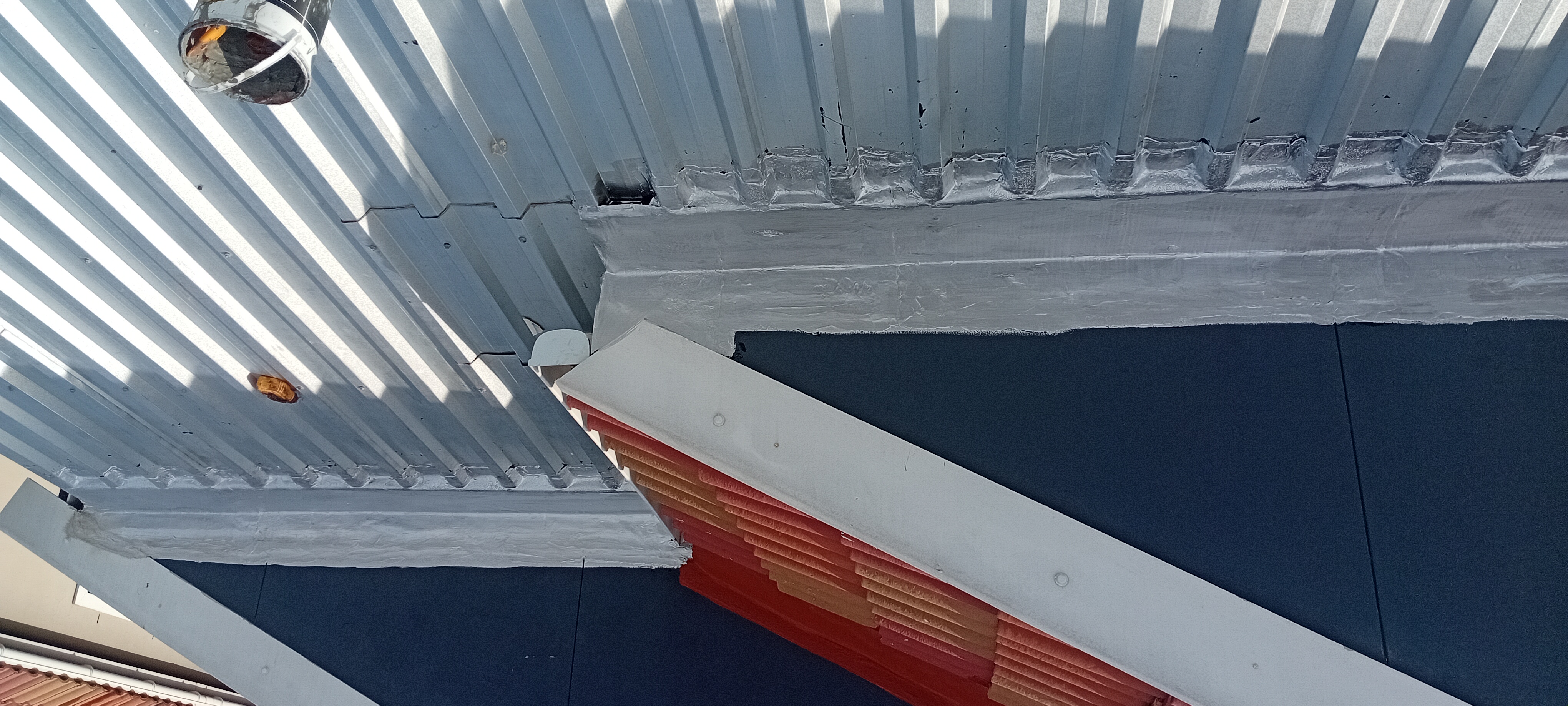 Completed parapet waterproofing and sealed roof junction